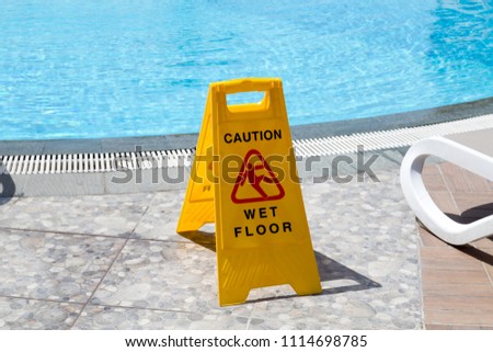 Warning sign, wet floor near the pool
