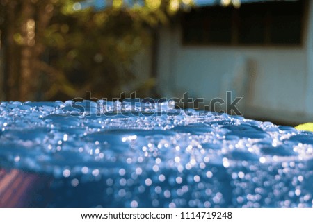 Shiny background of water drops over a bright blue surface