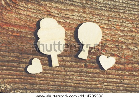 wooden trees and small hearts on piece of old wood