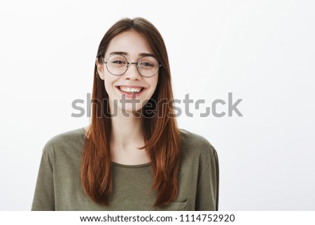 Who says glasses for nerds. Portrait of happy good-looking friendly woman in trendy eyewear, smiling broadly and chuckling feeling happiness and fun while talking with coworker during break