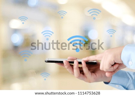 Man hand using smart phone with wifi icon over blur background, people on phone, technology and lifestyle
