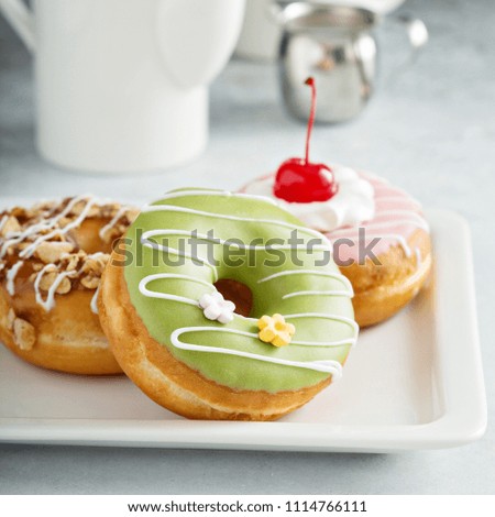 Assorted glazed fried donuts with coffee for breakfast