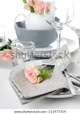 Festive table setting with roses and napkins on a white background