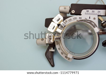Half of a test glasses for high myopia. This optician instrument contains three lens on. Vision care background. Royalty-Free Stock Photo #1114779971