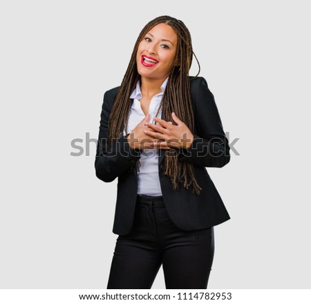Portrait of a young black business woman doing a romantic gesture, in love with someone or showing affection for some friend