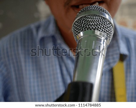 close up microphone of man singing to a microphone.