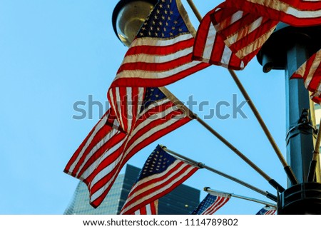 A shot of US Flags at Memorial with blue sky, clouds,