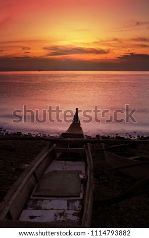 Wooden Boat and a Beautiful Sunrise at a tropical beach.