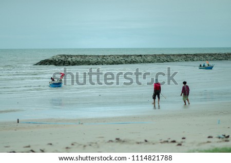 fisherman on the beach walk to boats