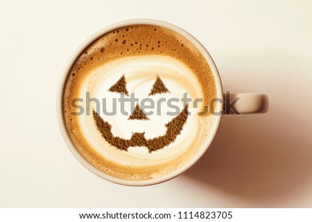 a cup of cappuccino coffee with a picture of a halloween symbol from cinnamon on milk foam Royalty-Free Stock Photo #1114823705