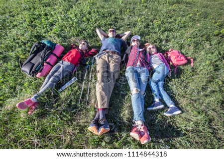 Family with two children resting on a meadow in a hike through mountains