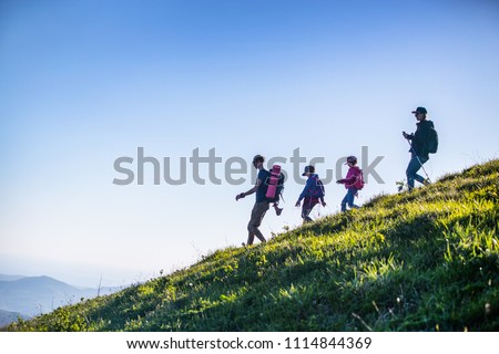  family with two kids have hiking  through the mountains