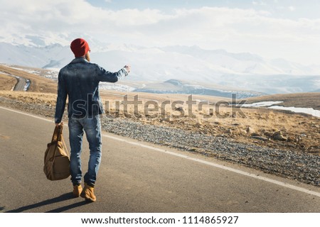 Tourism and people concept - stylish hipster walking along country road outdoors and pointing finger to something