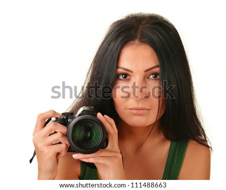 Young woman holding camera isolated on white. Taking pictures.