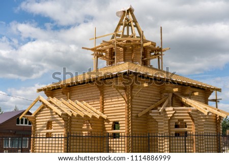 Wooden church under construction on the blue sky background with doves