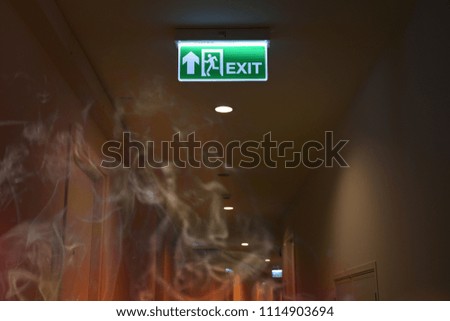 Emergency fire exit sign show the way to escape with the smoke fire burn.