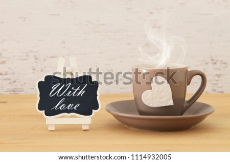 image of coffe cup with heart over wooden table