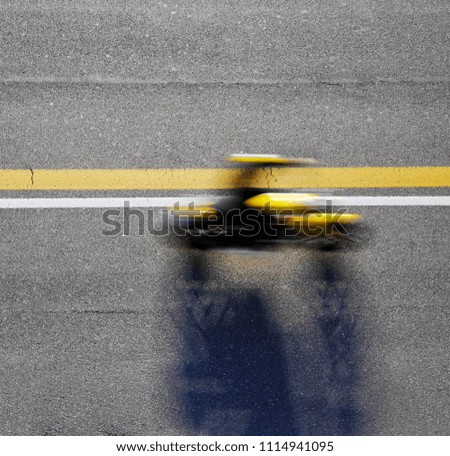 Fast motorbike racing on the road. Taken from above.