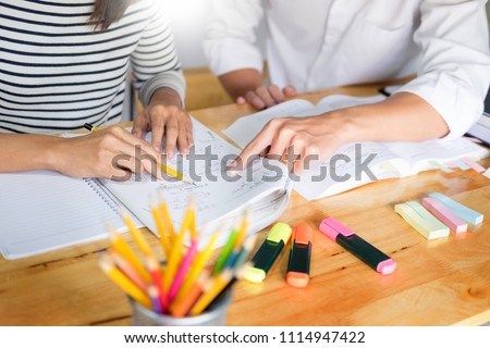 woman learn and teach tutor concept education  helping each other sitting in a table at class room Royalty-Free Stock Photo #1114947422