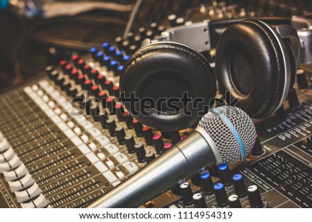 Close up instruments music background concept.Single microphone with headphones on sound mixer board in home recording studio.Free space for creative design text & wording mock up template.