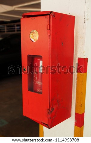 Fire extinguisher in red cabinet mounted on white wall