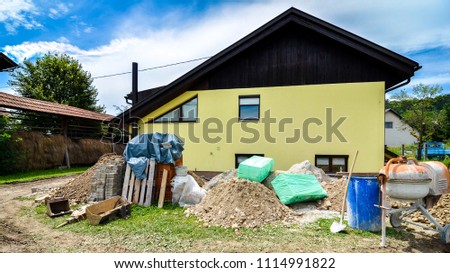 Rebuilding a family house and adding an extension. Setting up a construction site with tools and construction material for residential construction project.