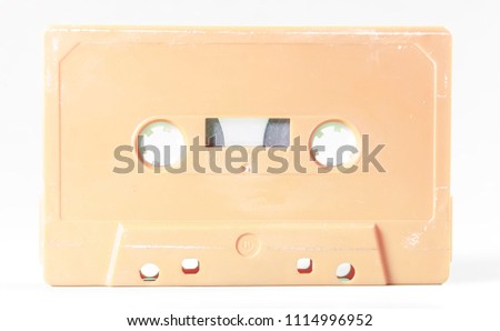A vintage cassette tape from the 1980s era (obsolete music technology). Color: cream, sand. White background.