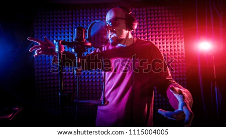 The singer sings with a microphone in the recording studio. Modern background