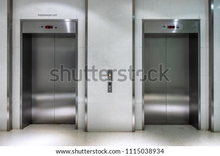 Metallic elevator two gate closed of passenger lift at lobby