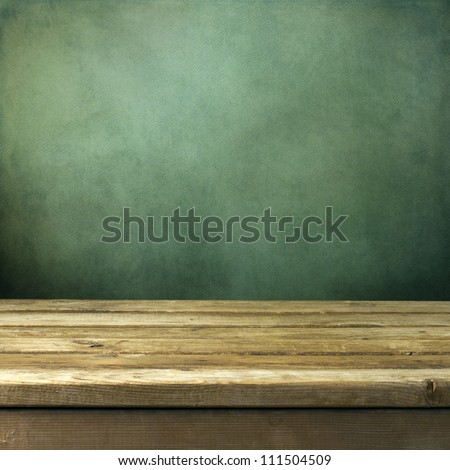 Wooden deck table on green grunge background