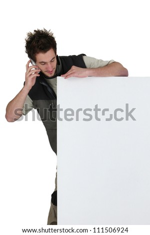 Tradesman standing behind a blank sign