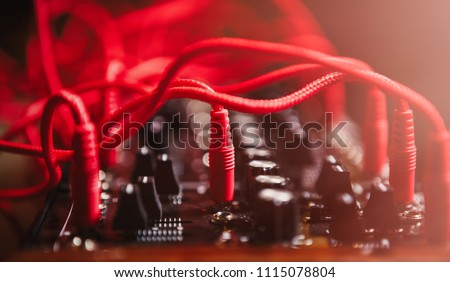 Analog modular synthesizer device. Audio cables connected to synth panel in sound recording studio. Download stock photo of professional musical equipment Royalty-Free Stock Photo #1115078804