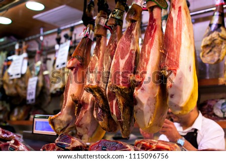 Spanish hamon in barcelona market, jamon iberico in view black leg pork isolated, traditional national spain meat in store, serrano prosciutto food on background gastronomy, bacon berian on cuisine Royalty-Free Stock Photo #1115096756