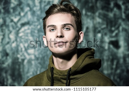 Portrait of a teenage boy over grunge background. Studio shot. Teen fashion.