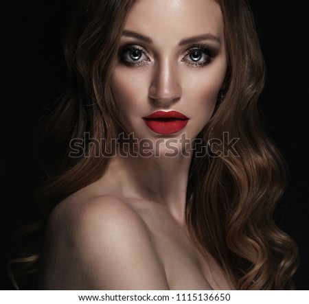 Blonde fashion girl with long and shiny curly hair. Red lips and bright make up.