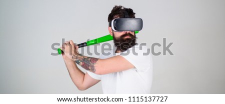 Hipster with stylish beard testing virtual reality gaming equipment. Gamer with hipster beard playing baseball, sport concept. Bearded man in VR headset mastering skills isolated on gray background.