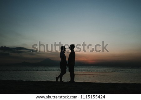 
Lovely couple on vacation in the Gili Islands enjoying a colorful sunset in Indonesia. Photograph and vacation.