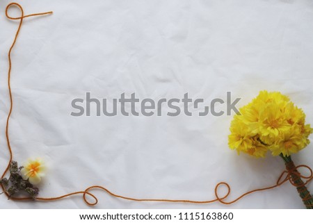 Bouquet of yellow flowers at right angles,
Brown thread on the side and bottom,
Is a rectangular frame,
White background.