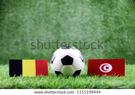 ball with Belgium VS Tunisia
 flag match on Green grass football 2018 Royalty-Free Stock Photo #1115198444