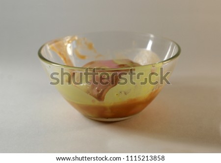 Hollow, ugly ice cream in a bowl on a white background