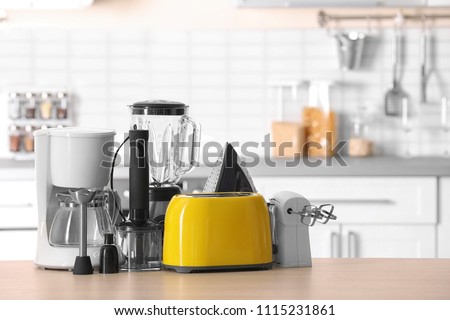 Household and kitchen appliances on table against blurred background Royalty-Free Stock Photo #1115231861