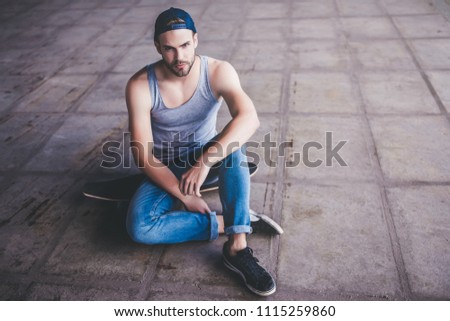 Young man skateboarder. Male teenager with longboard in skatepark.