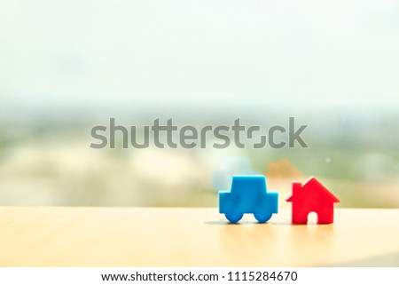 Car model and house model on wooden boards.Have a background office.Credit or loan and earning for home in the family.Use money to exchange or buy in business and real estate.                 