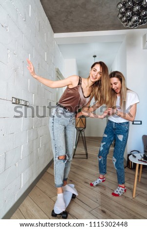 Friends having fun with skateboard at new apartment