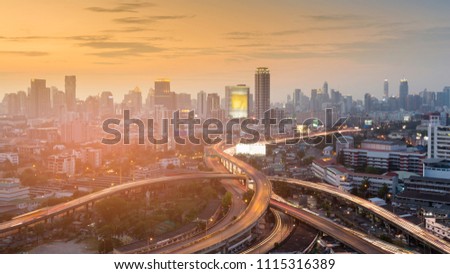 Highway intersection with city business downtown and sunset sky background, cityscape 