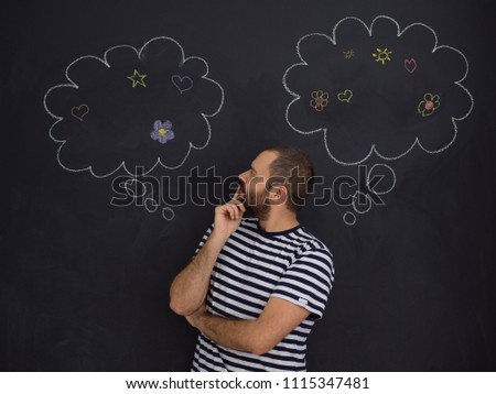 young future father thinking about names for his unborn baby to writing them on a black chalkboard
