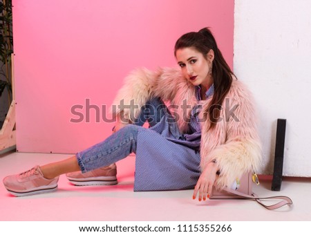 Fashionable photo, a girl model in jeans and a fur coat. A stylish image, fashion and style.