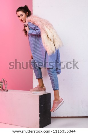 Fashionable photo, a girl model in jeans and a fur coat. A stylish image, fashion and style.
