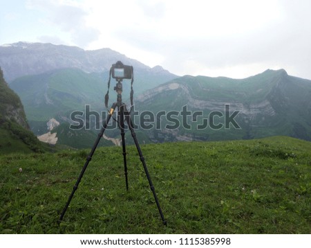 Camera on a tripod, shooting foggy mountains