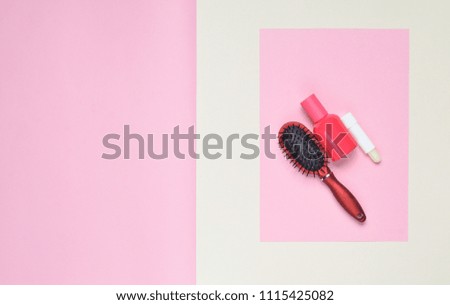 Hairbrush, lipstick, bottle of perfume on a pink pastel background. Minimalism. Top View
